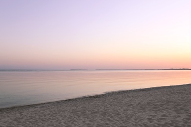 Photo of Sandy beach near sea at summer sunset