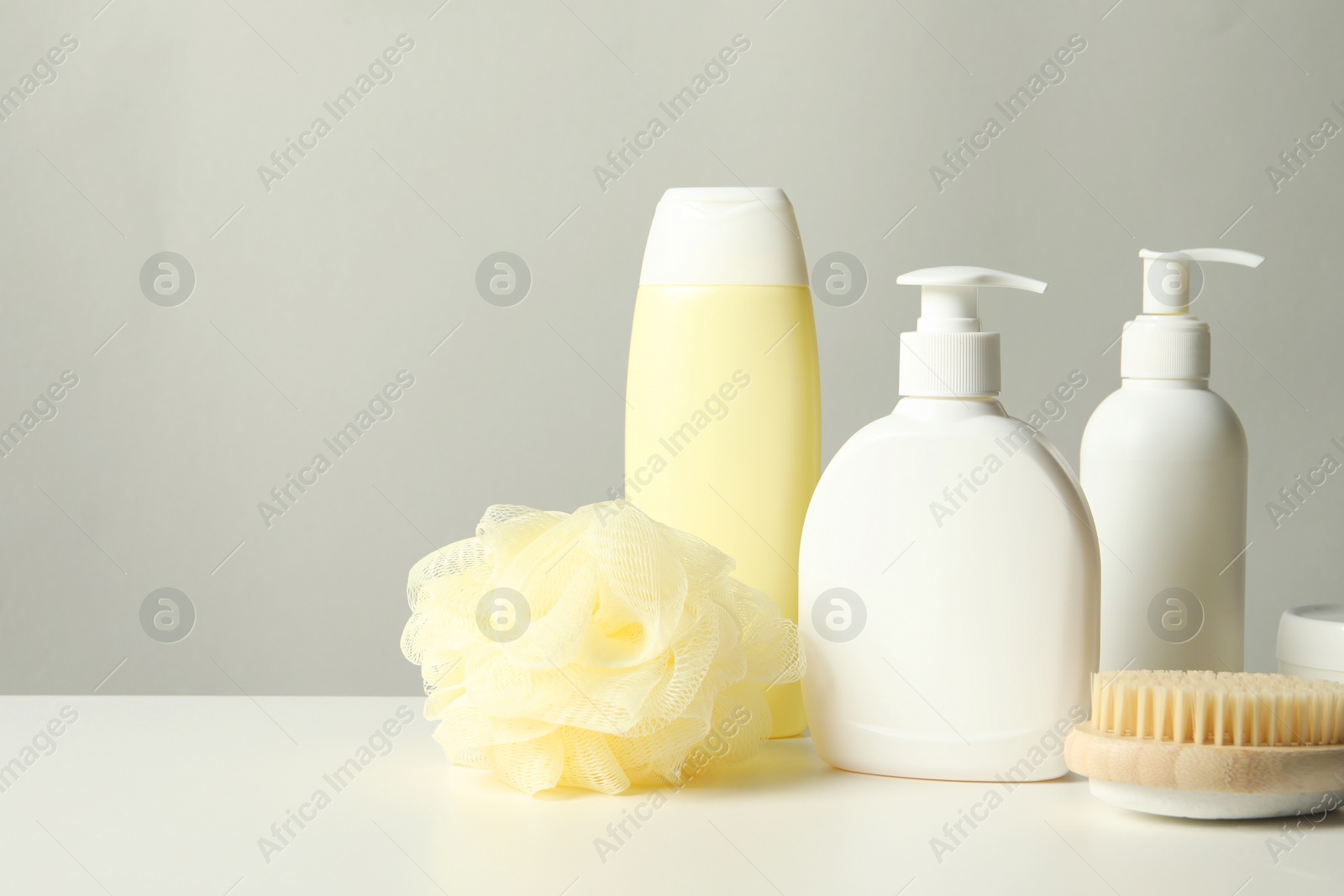 Photo of Different bath accessories on white table against grey background. Space for text