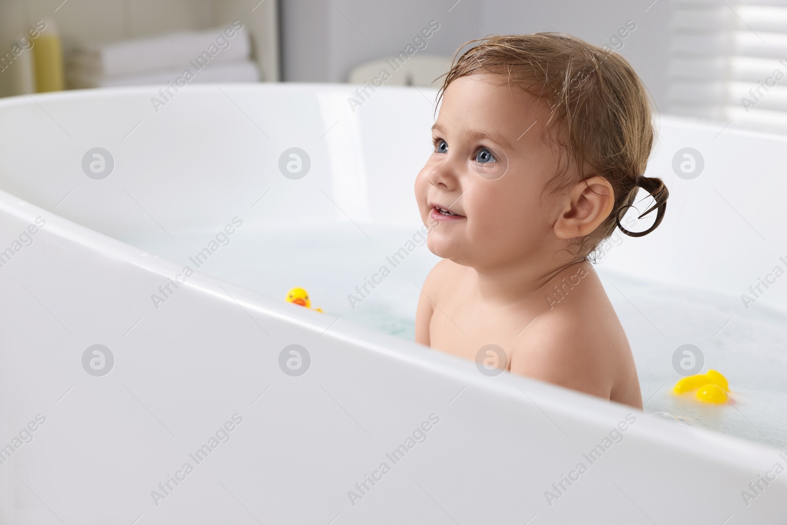 Photo of Cute little girl taking bath at home