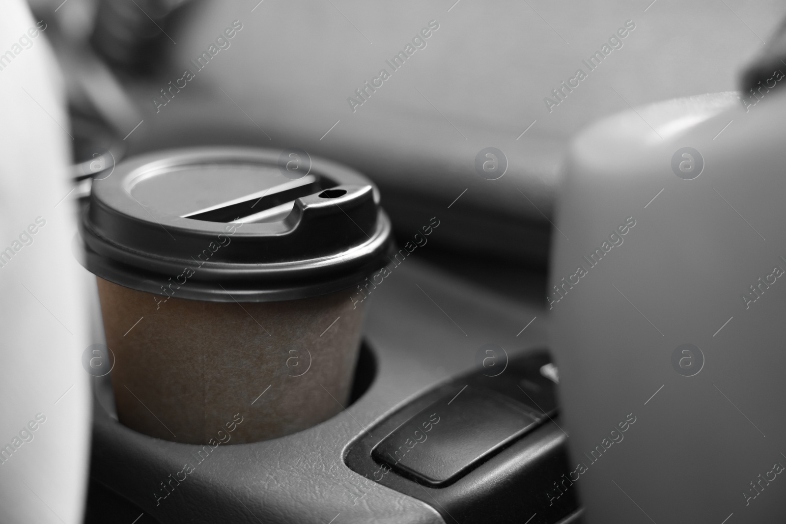 Photo of Coffee to go. Paper cup with tasty drink in holder inside of car, closeup