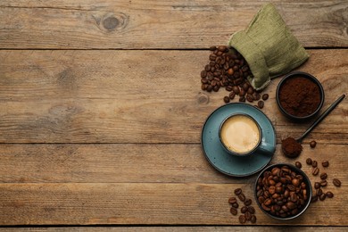 Photo of Flat lay composition with coffee grounds and roasted beans on wooden table, space for text