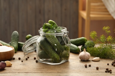 Photo of Pickling jar with fresh cucumbers on wooden kitchen table