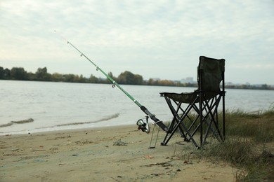 Photo of Folding chairs and fishing rod at riverside