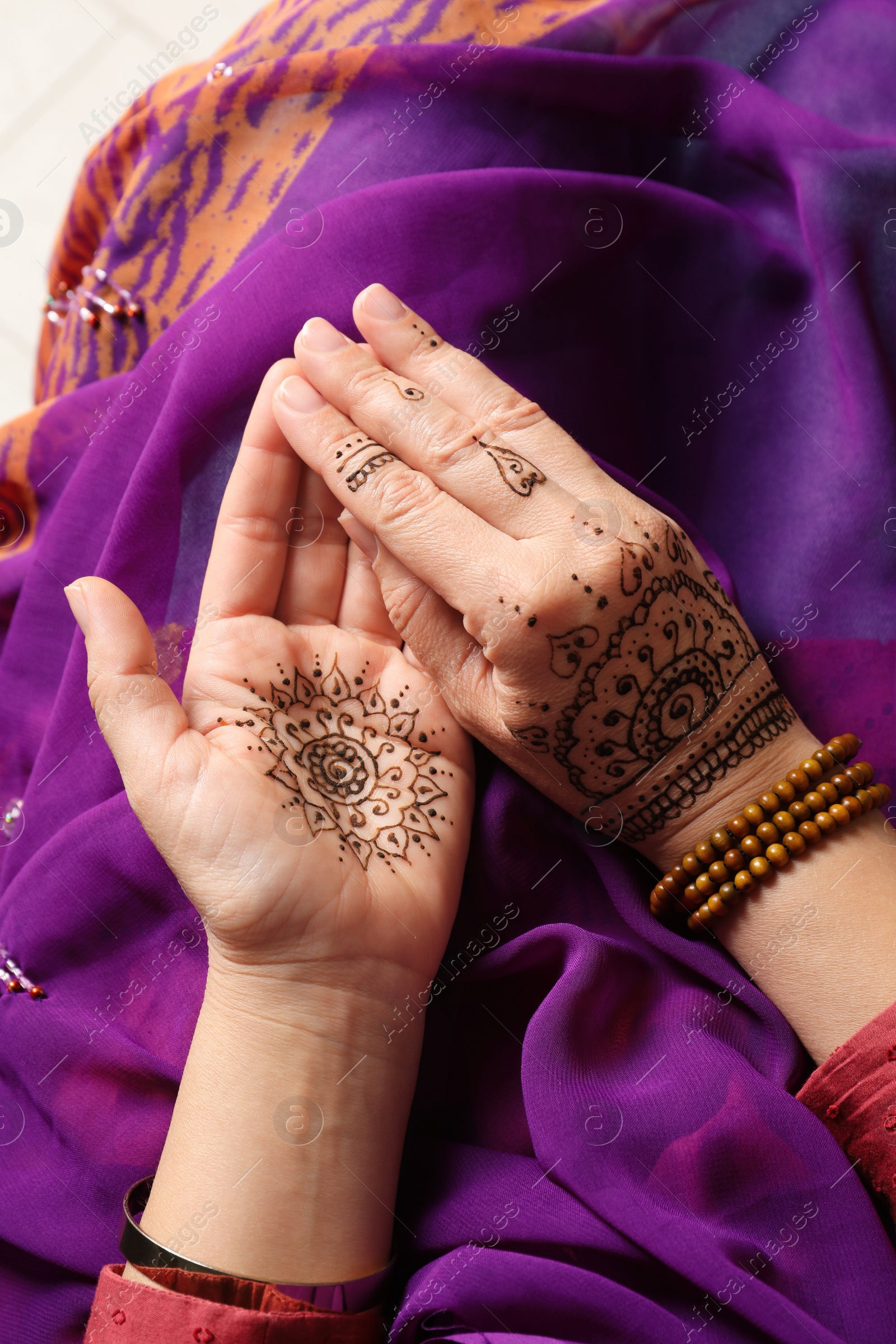 Photo of Woman with beautiful henna tattoos on hands, closeup. Traditional mehndi