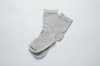 Photo of Pair of grey socks on light background, flat lay