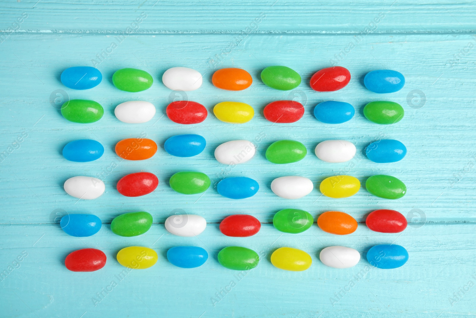 Photo of Flat lay composition with jelly beans on color background