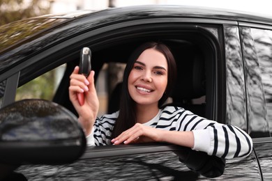 Photo of Woman holding car flip key inside her vehicle