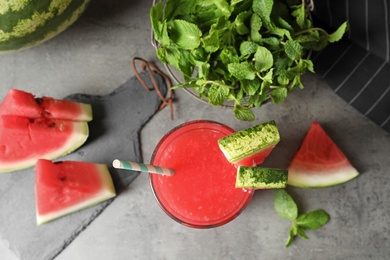 Photo of Summer watermelon drink in glass, sliced fruit and mint on table, top view