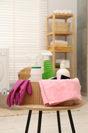 Different cleaning products in wooden box on table indoors