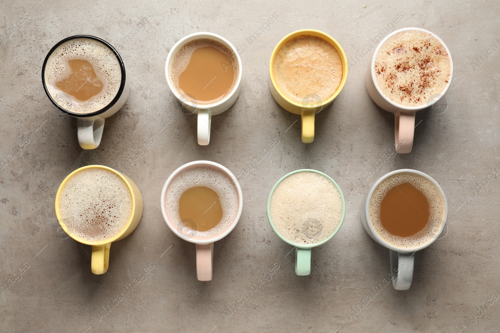 Photo of Many cups with different aromatic coffee on light grey table, flat lay