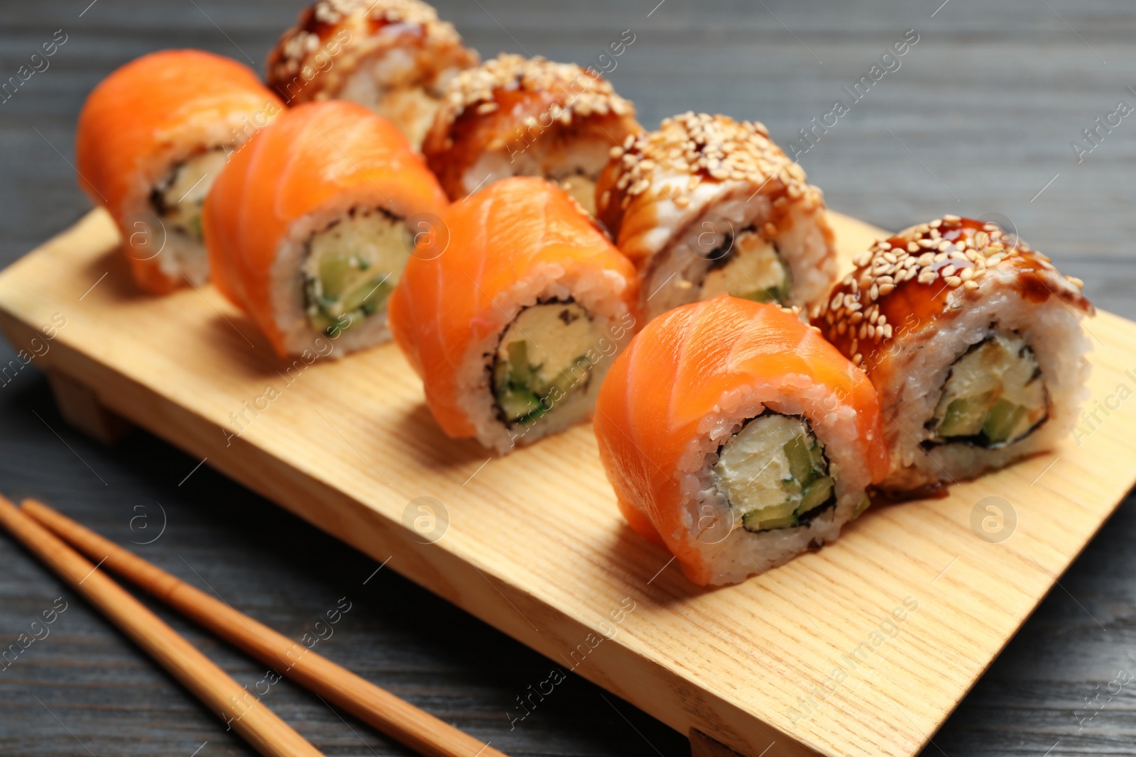 Photo of Set of delicious sushi rolls on grey wooden table