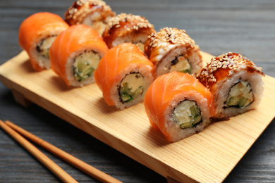 Set of delicious sushi rolls on grey wooden table