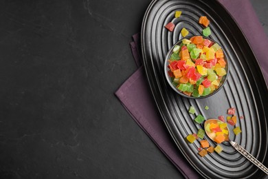 Photo of Mix of delicious candied fruits on black table, flat lay. Space for text