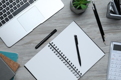 Photo of Flat lay composition with stylish notebook and stationery on light grey wooden table