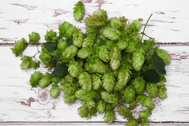 Photo of Fresh green hops on white wooden table, flat lay