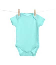Baby onesie hanging on clothes line against white background. Laundry day