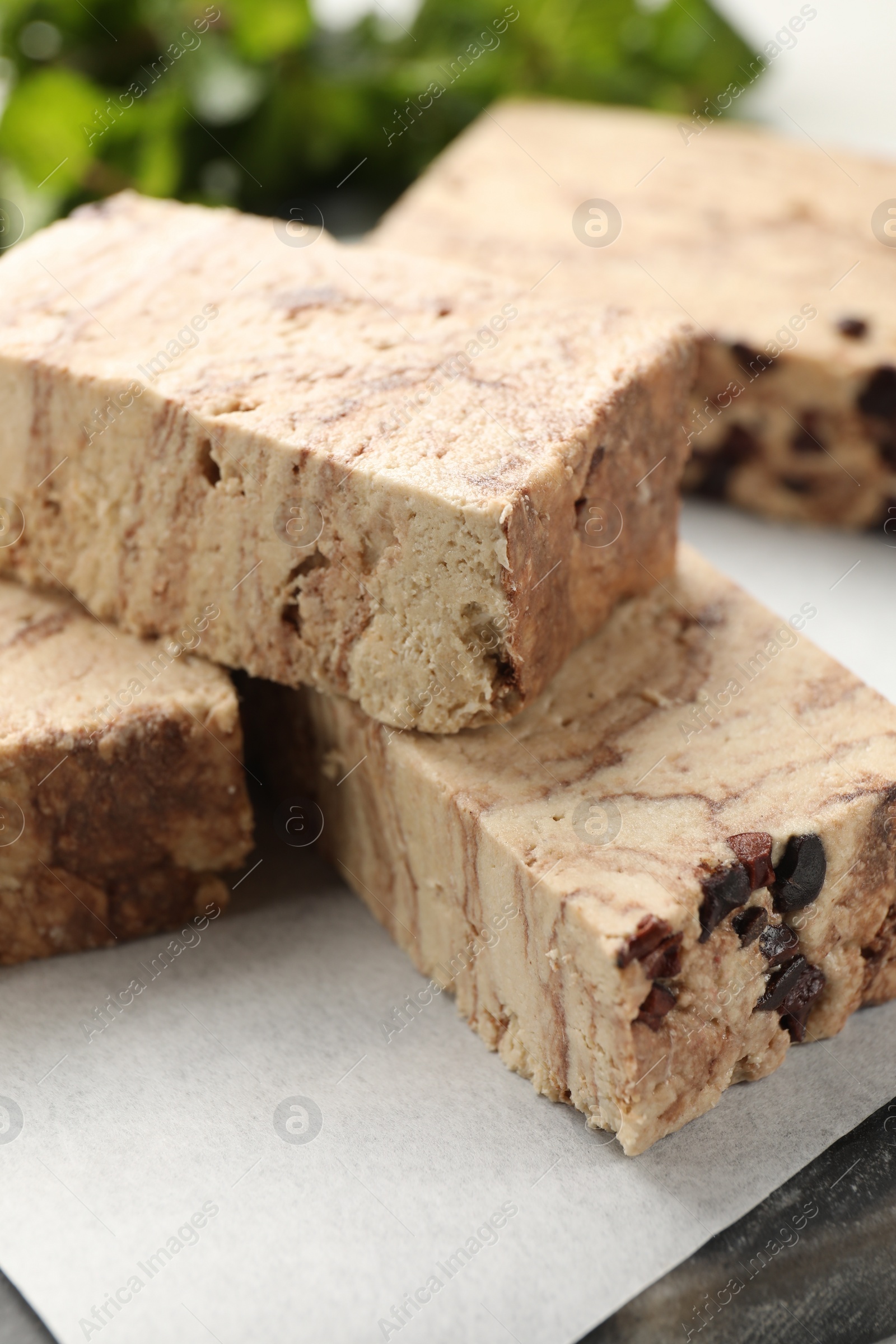 Photo of Pieces of tasty chocolate halva on table, closeup