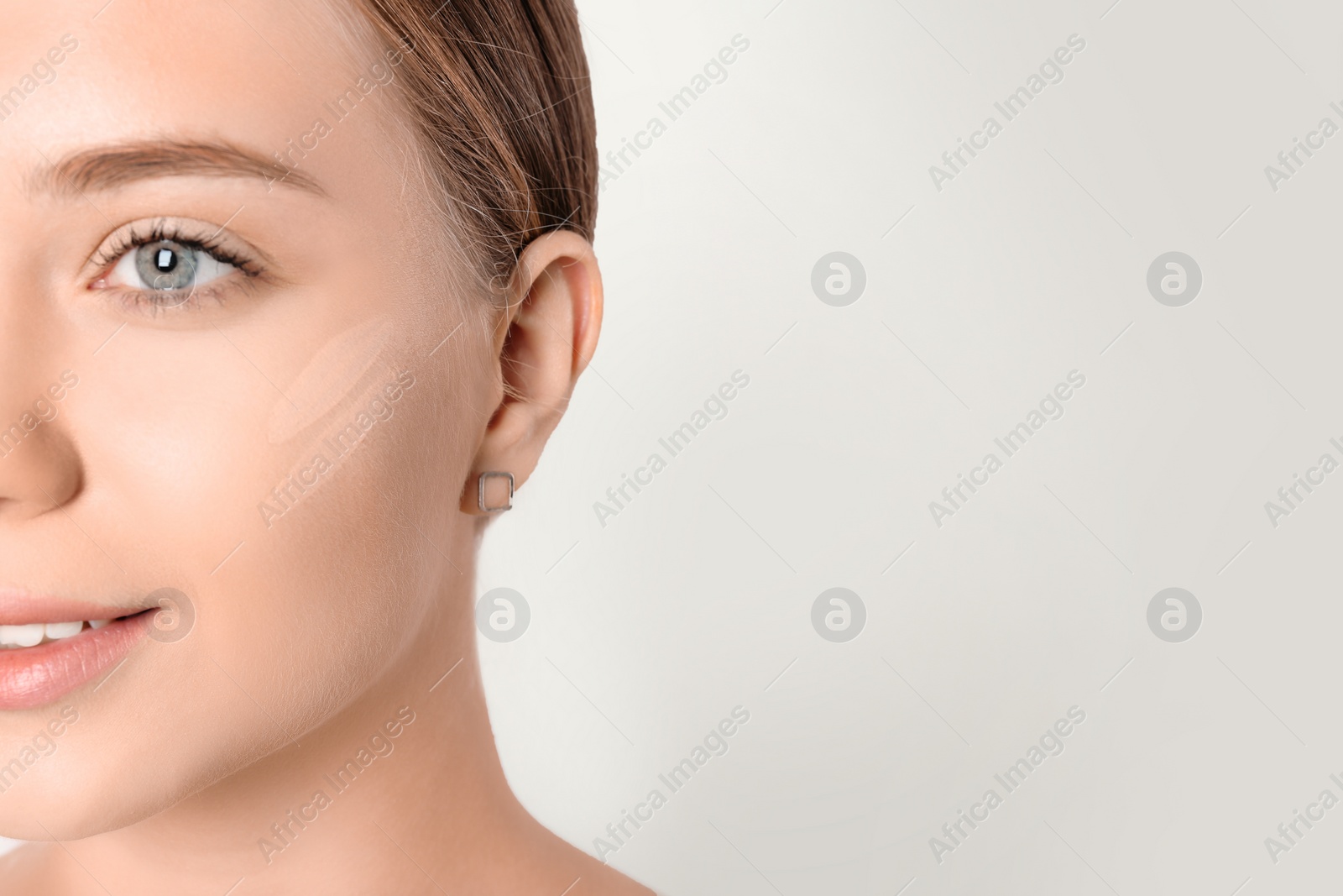 Photo of Portrait of beautiful young woman with makeup smears on face against white background