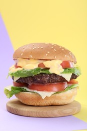Photo of Burger with delicious patty on color background