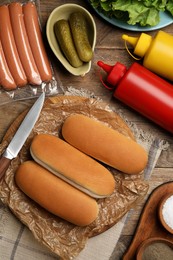Different tasty ingredients for hot dog on wooden table, flat lay