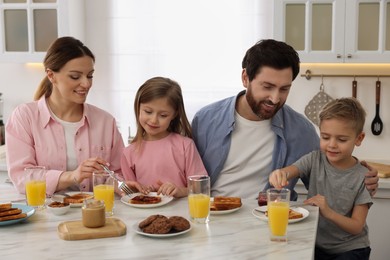 Happy family having breakfast at table in kitchen