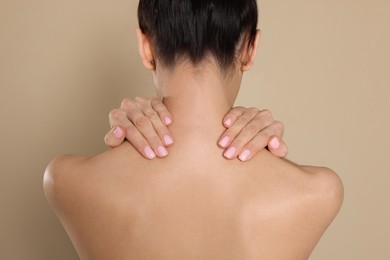 Photo of Back view of woman with perfect smooth skin on beige background, closeup