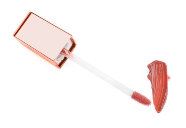 Stroke of color lip gloss and applicator isolated on white, above view