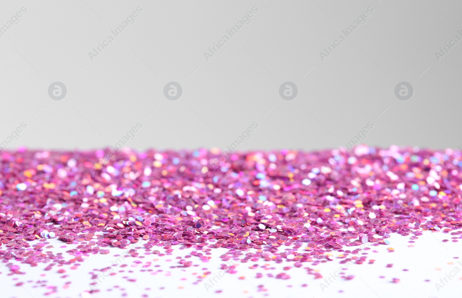 Photo of Beautiful shiny paillettes on light background. Space for text