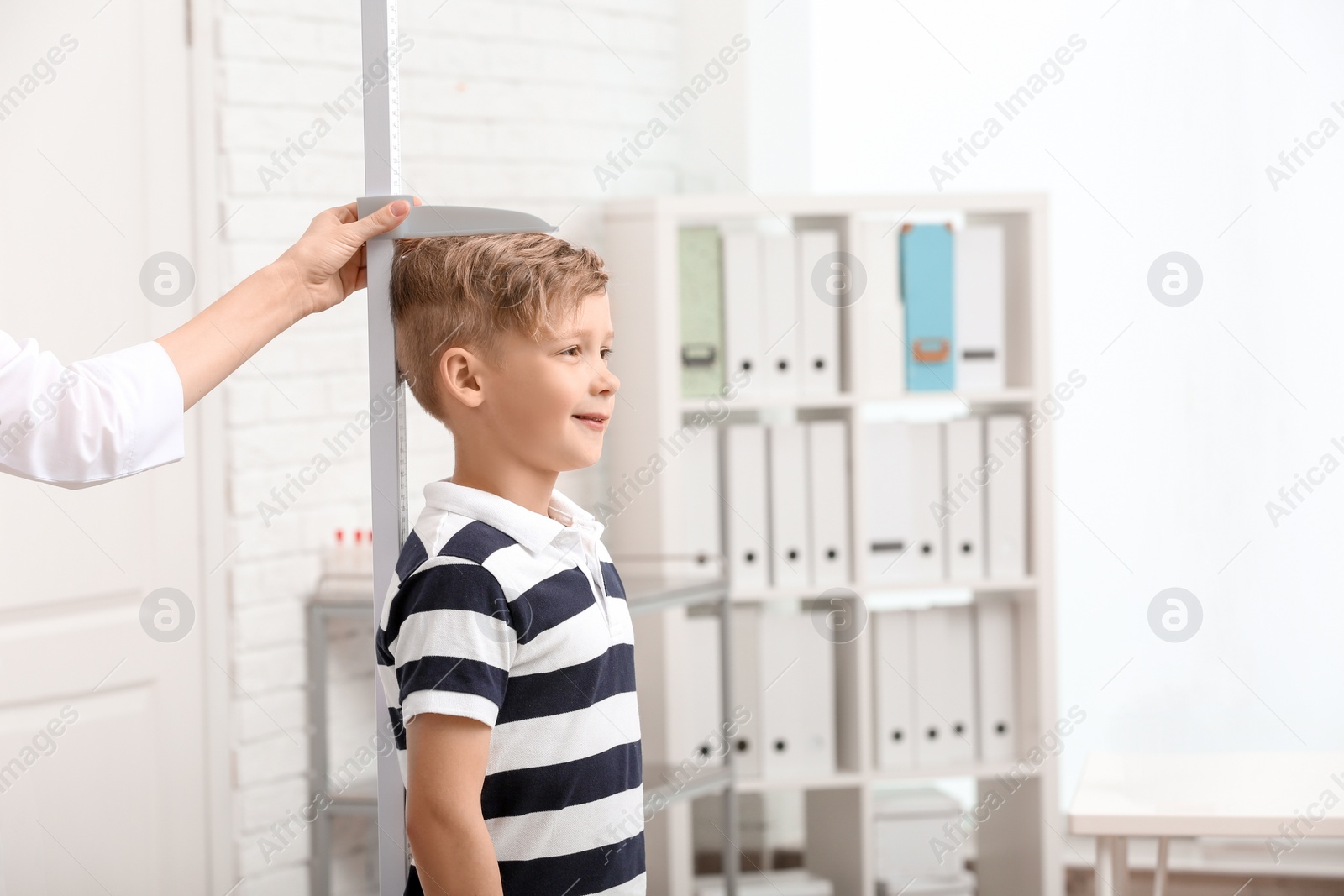 Photo of Doctor measuring little boy's height in hospital