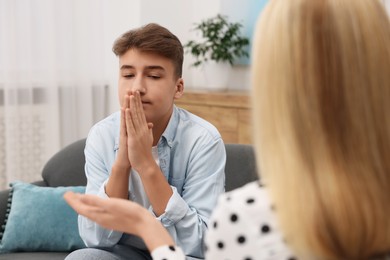 Photo of Psychologist working with teenage boy in office