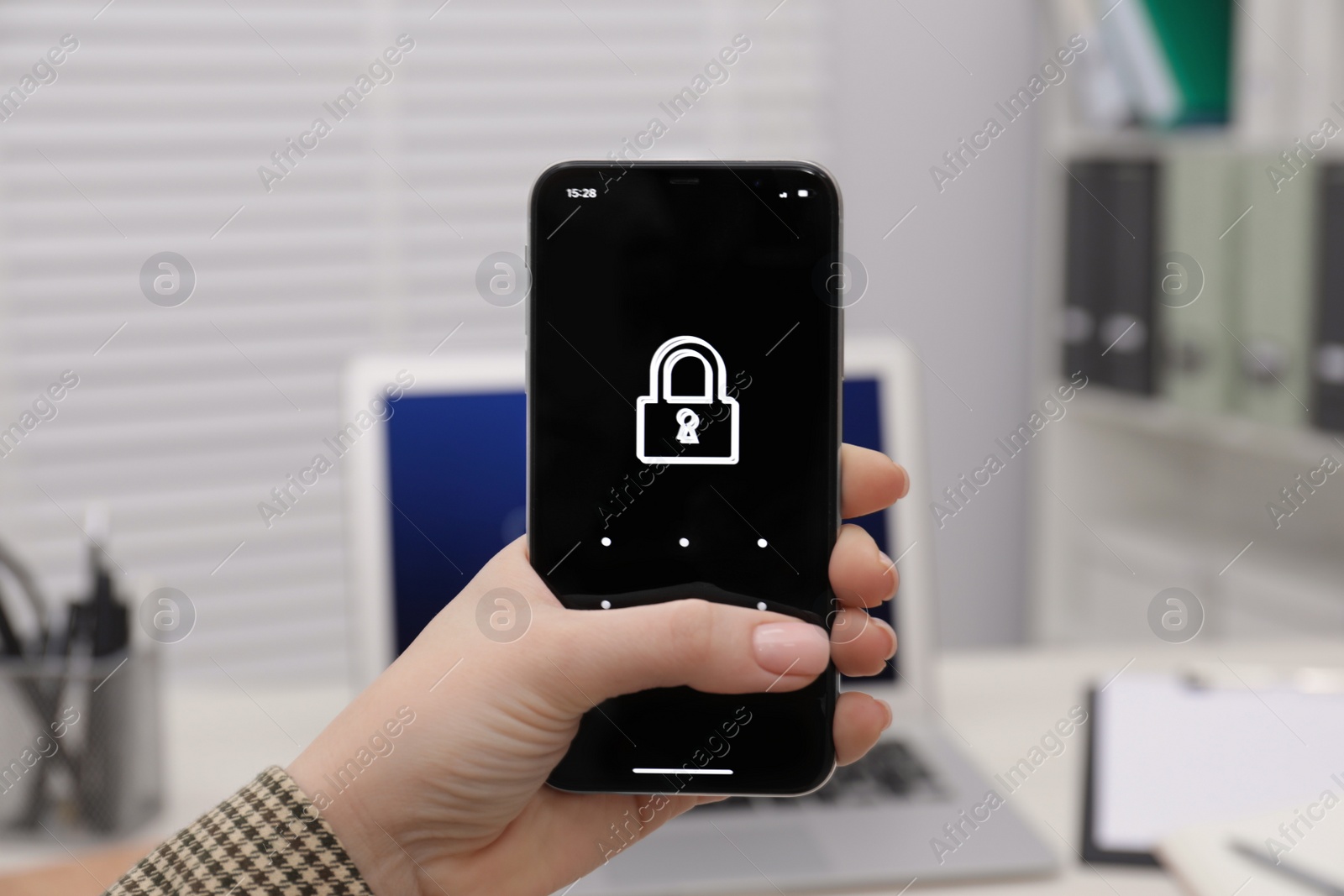 Photo of Woman holding smartphone with blocked screen at workplace, closeup. Reliable password