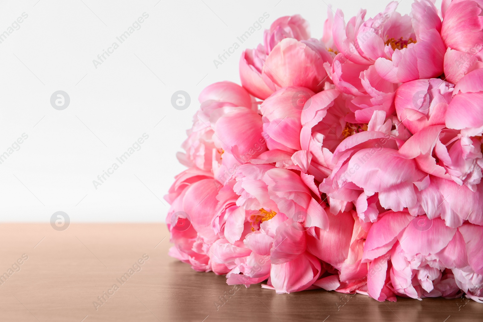 Photo of Bunch of beautiful pink peonies on wooden table, closeup. Space for text