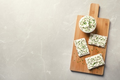 Tasty snack with cream cheese on gray table, flat lay. Space for text