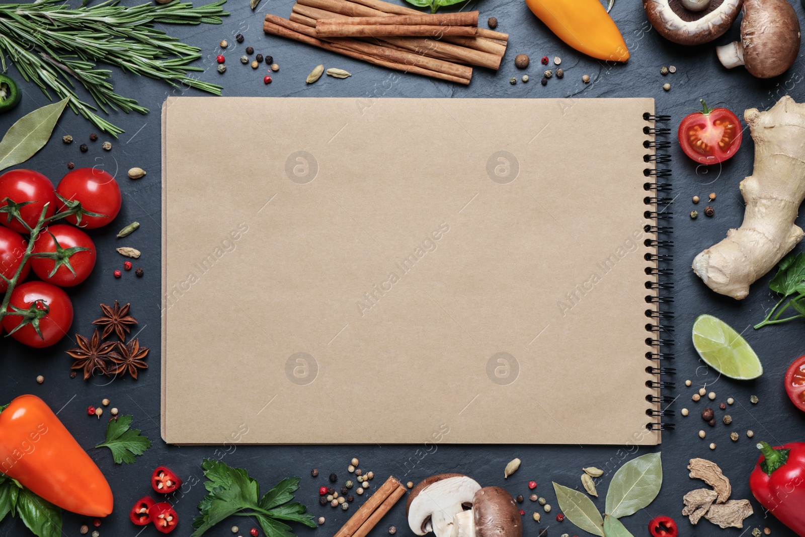 Photo of Open recipe book and different ingredients on black table, flat lay. Space for text