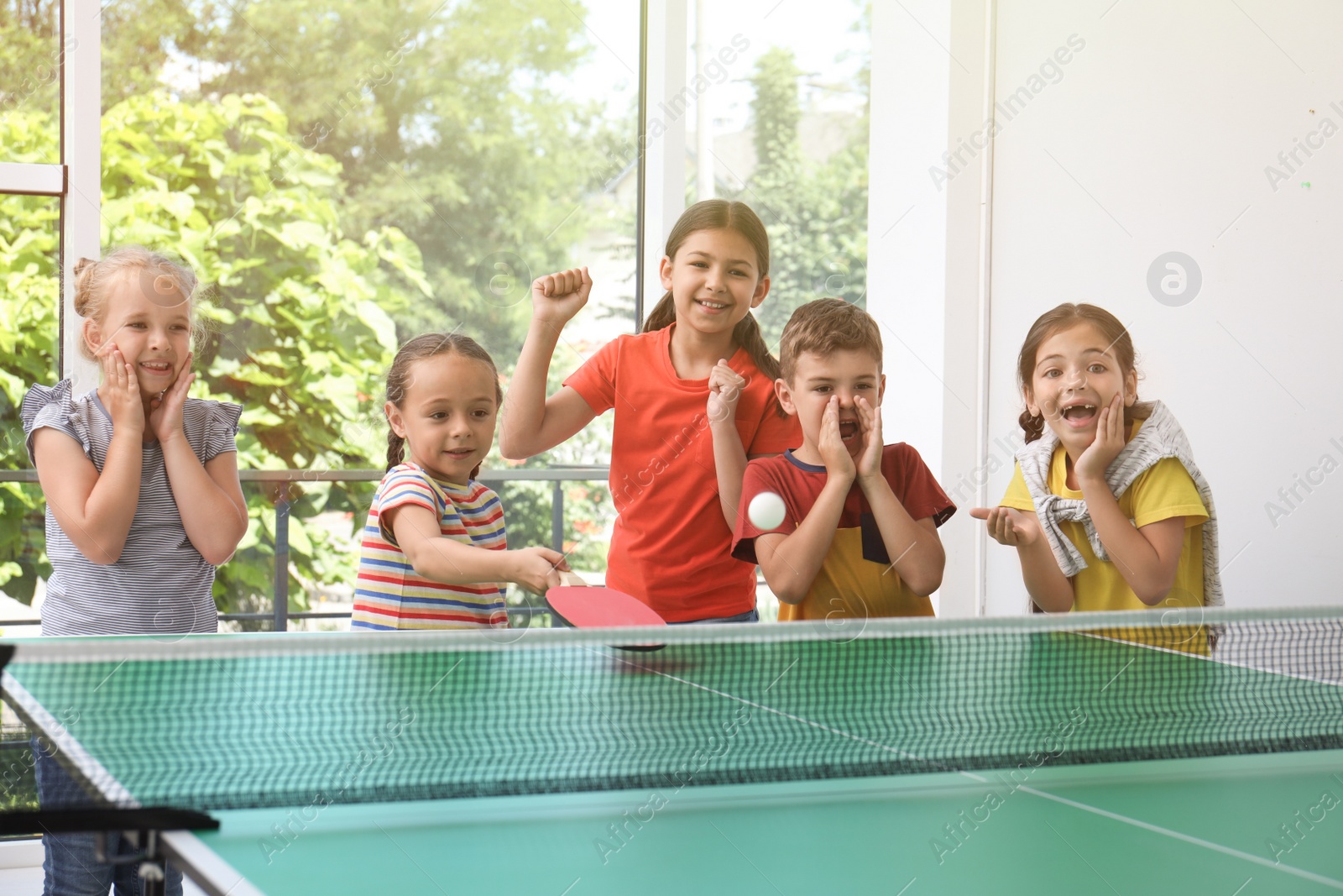 Photo of Cute happy children playing ping pong indoors