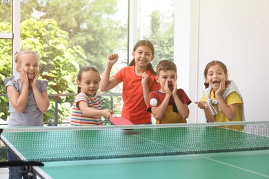 Photo of Cute happy children playing ping pong indoors