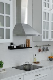 Photo of Elegant kitchen interior with range hood and furniture