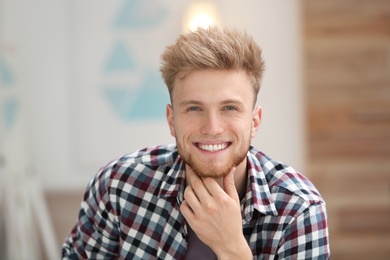 Portrait of handsome young man in room