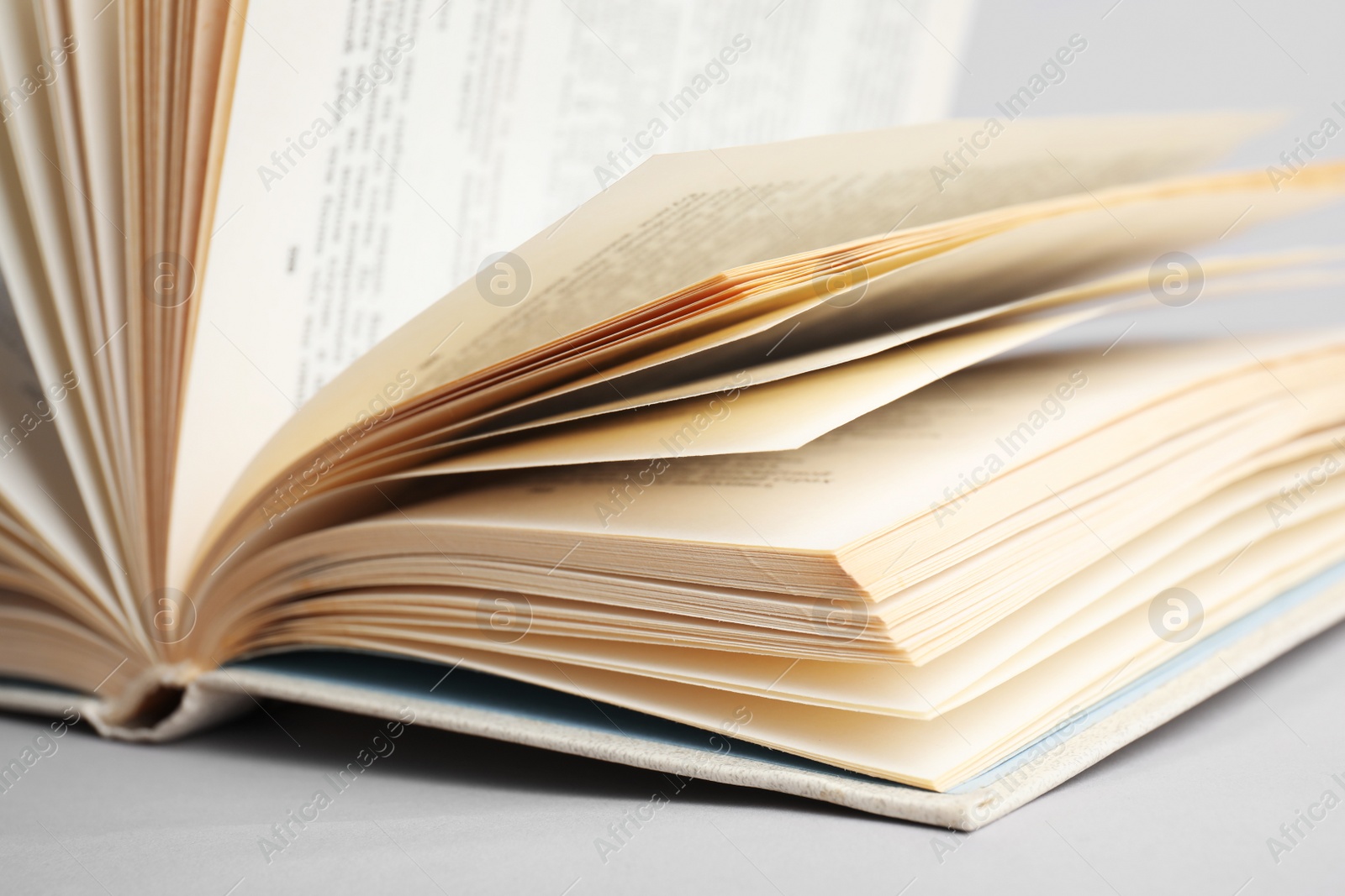 Photo of Closeup view of open book on light background