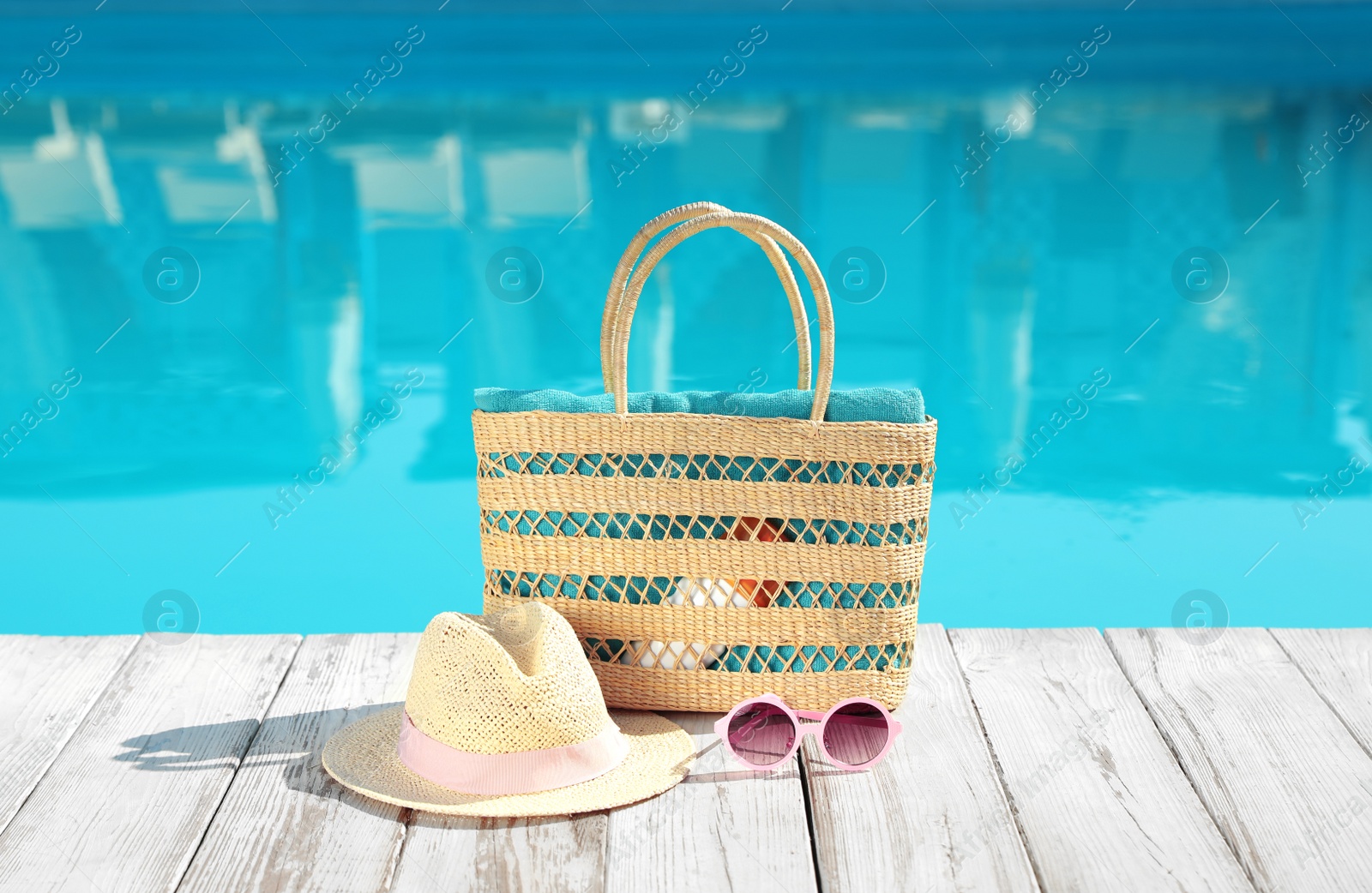 Photo of Beach accessories on wooden deck near outdoor swimming pool