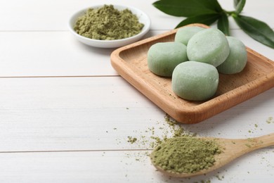 Delicious matcha mochi on white wooden table, space for text