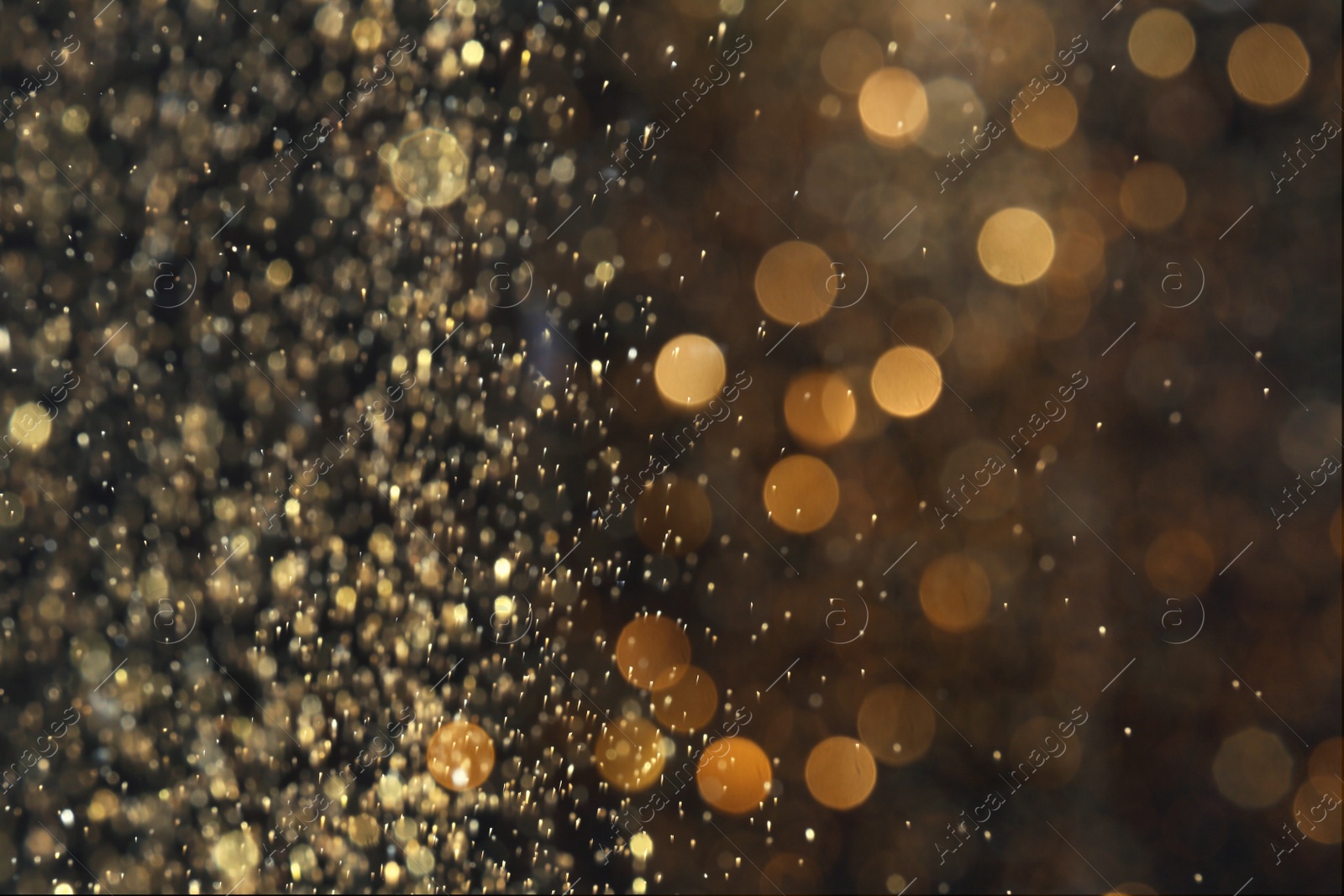 Photo of Blurred view of golden lights on black background. Bokeh effect