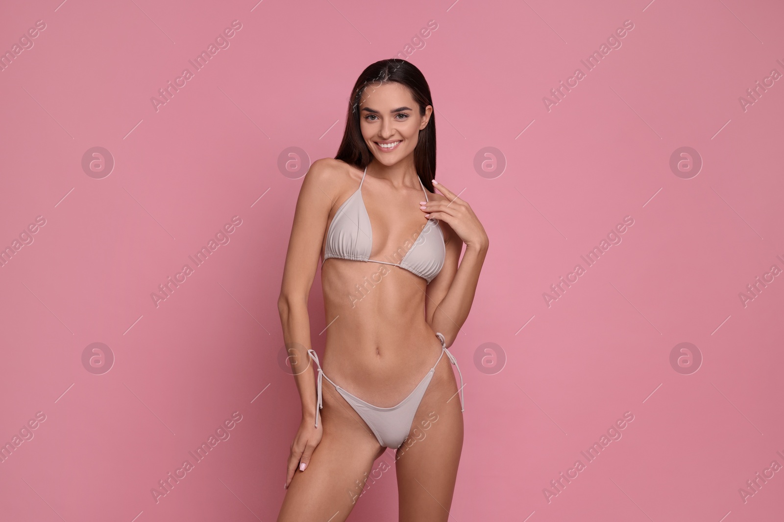 Photo of Young woman in stylish bikini on pink background