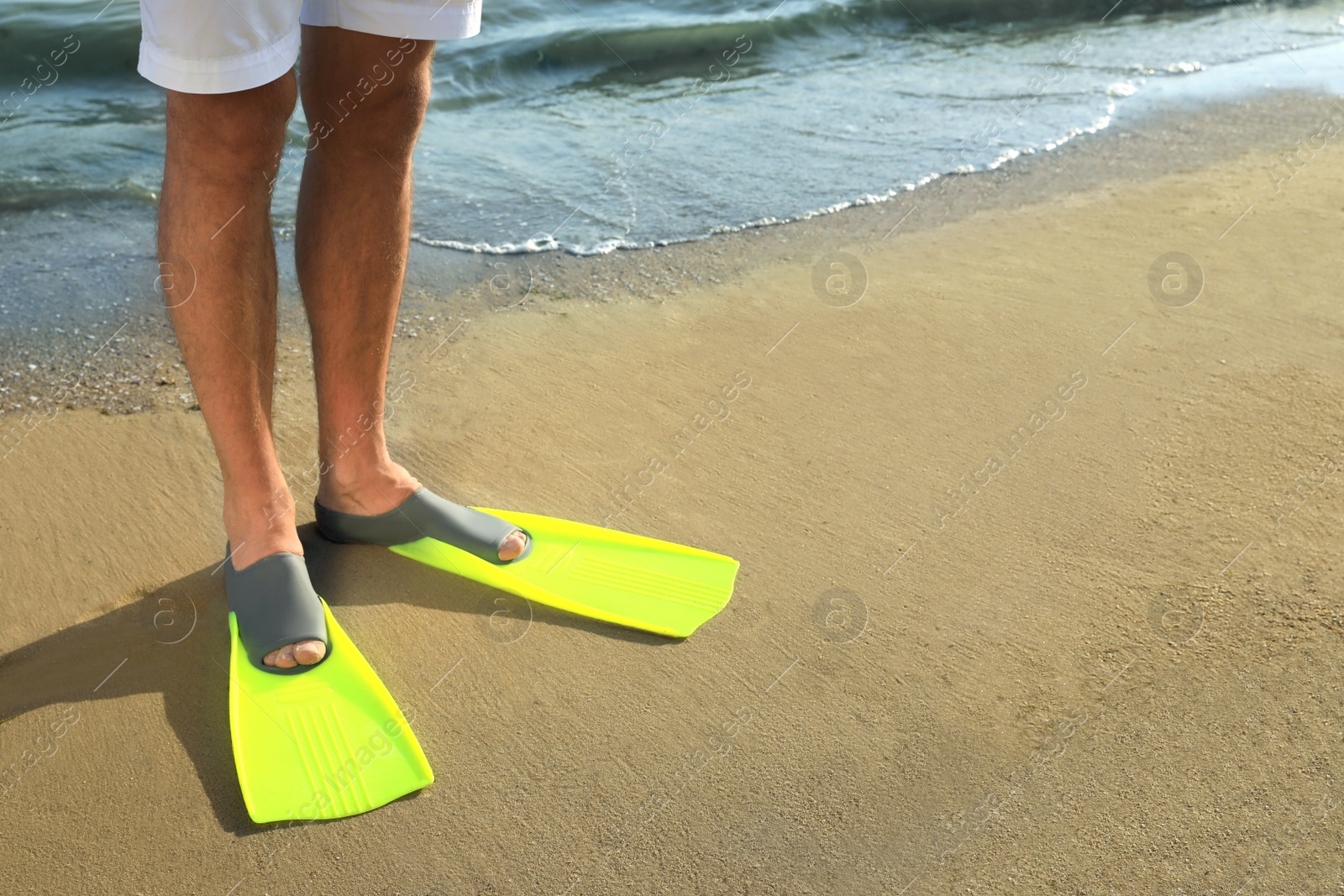 Photo of Man in flippers on sandy beach, closeup