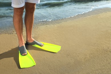 Photo of Man in flippers on sandy beach, closeup