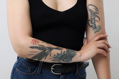 Photo of Woman with cool tattoos on gray background, closeup