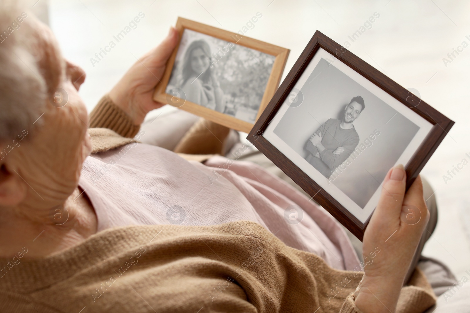 Photo of Elderly woman with framed photos at home