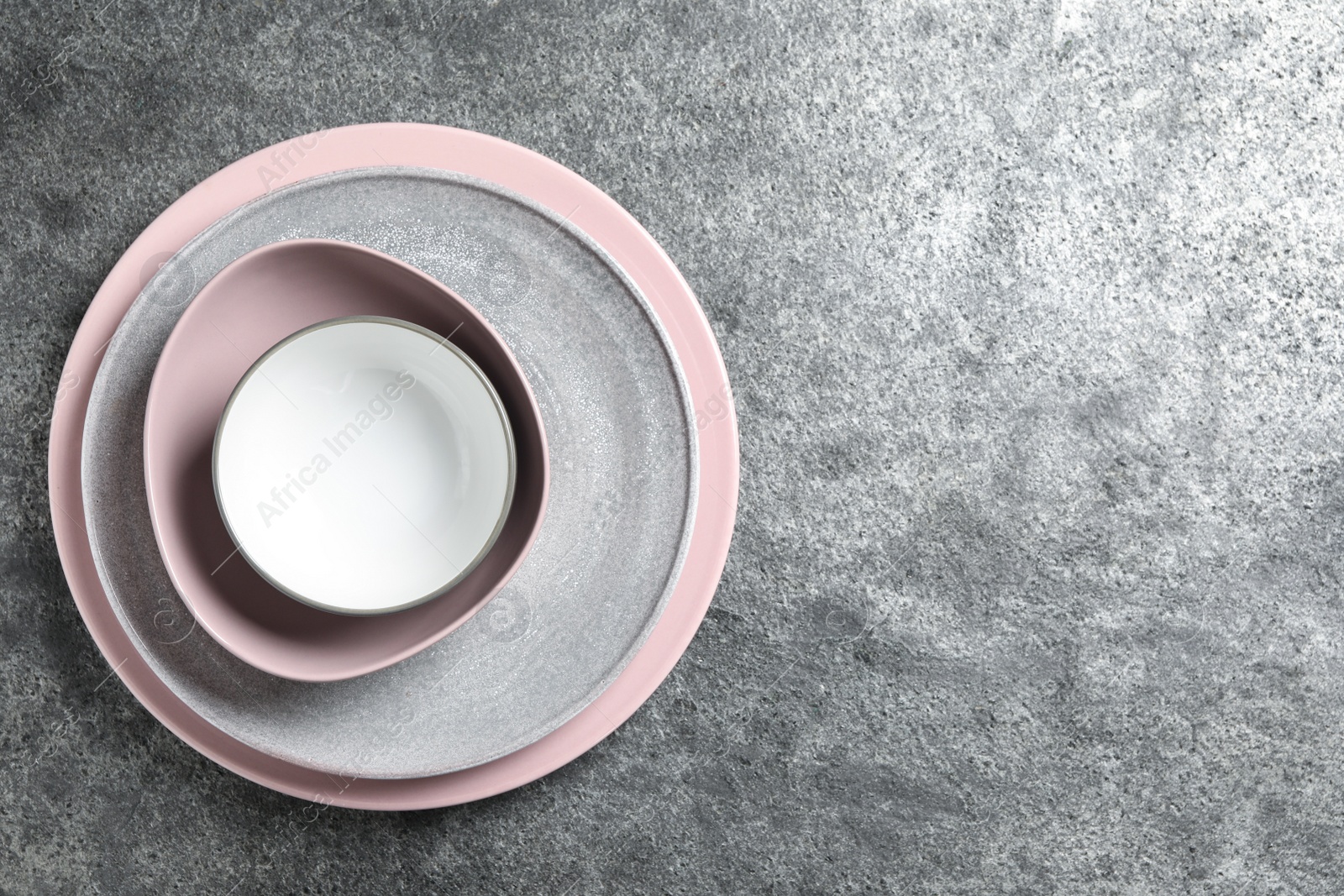 Photo of Stack of clean dishes on grey table, top view. Space for text