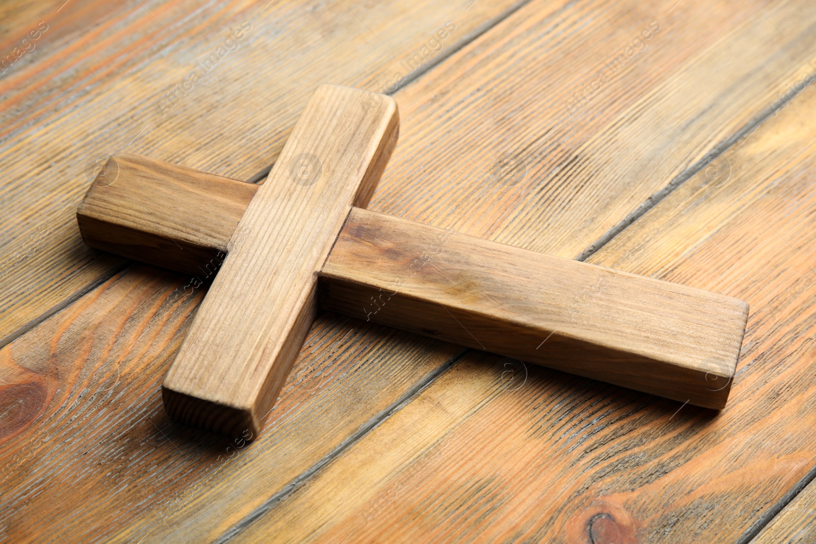 Photo of Christian cross on wooden background, closeup. Religion concept