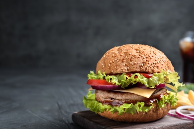 Board with tasty burger on table. Space for text